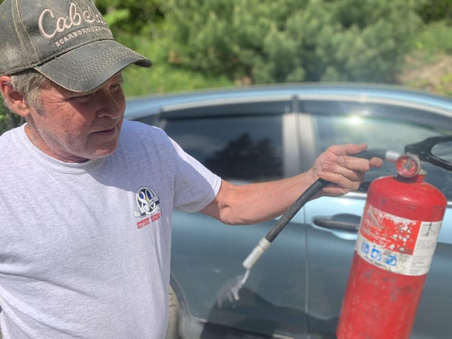 Man holding used fire extinguisher